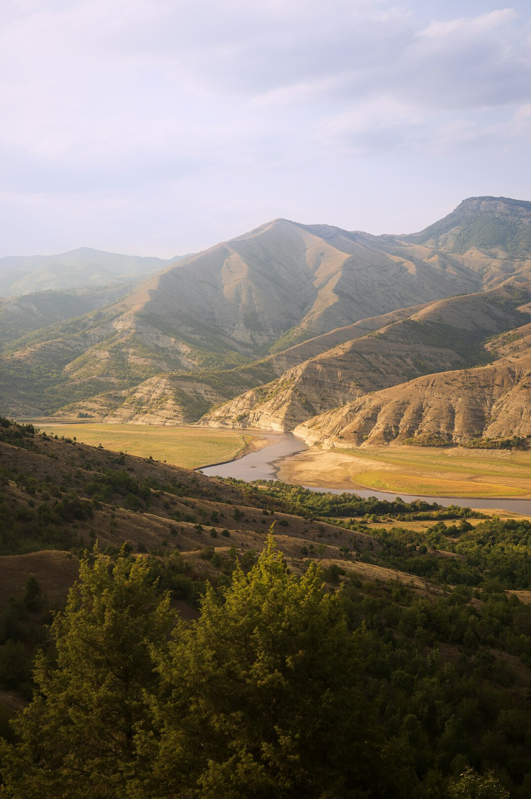 Sunlit valley with mountains and a river